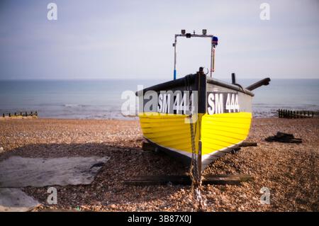 Small fishing boat SM444 on the beach at Worthing in soft focus Stock Photo