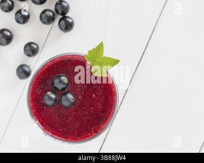 Delicious black currant smoothie with fresh berries on white wood background with copy space. Top view or flat lay Stock Photo