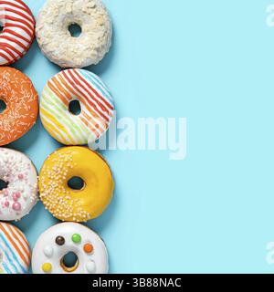 Delicious glazed donuts on blue background. Square flat lay - set of different colorful donuts or doughnuts on blue with copy space for text or design Stock Photo