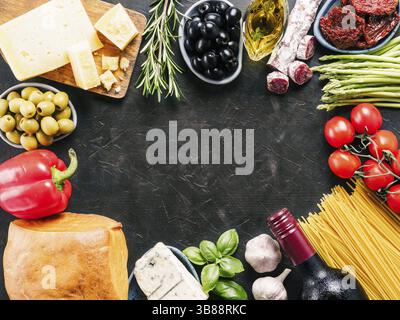 Italian kitchen and italian food concept. Vegetables of italian region, pasta, parmesan cheese, gorgonzola, peperoni, ciabatta, herbs and wine bottle Stock Photo