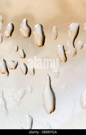 various shapes of liquid droplets on a metallic surface Stock Photo