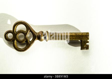 Antique Brass Skeleton Key on White Background, shown at an angle with a macro closeup Stock Photo