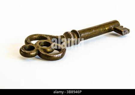 Antique Brass Skeleton Key on White Background, shown at an angle with a macro closeup Stock Photo