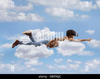 African american man flying and in the sky with a vr headset Stock Photo