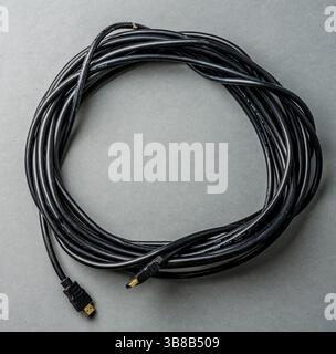Long coiled HDMI cable on grey background Stock Photo