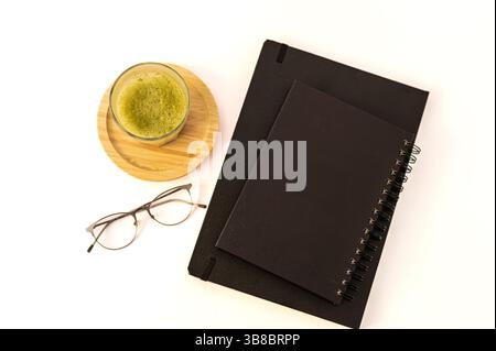 Close-up of a stack of books and a freshly made matcha latte in a ceramic cup, creating a warm and calming reading atmosphere. Stock Photo