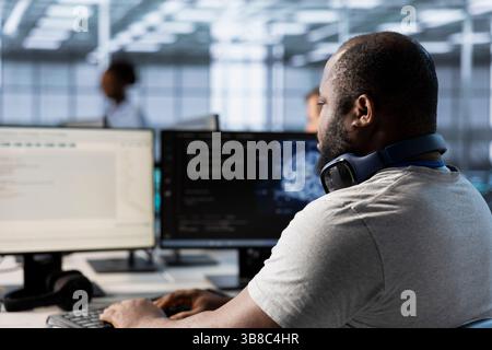Computer scientist using artificial intelligence technology to optimize data center performance. African american IT expert in server farm using AI tech to accurately forecast potential issues Stock Photo