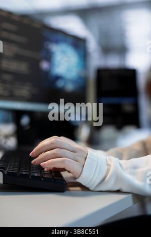 Software developer doing data center automation using AI and machine learning tools. Focus on IT employee integrating artificial intelligence driven automation in server hub operations, close up Stock Photo