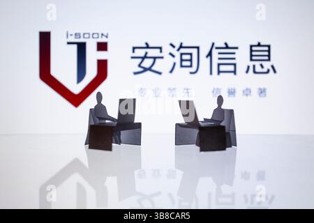 February 22, 2024, Asuncion, Paraguay: I-Soon logo is displayed behind cut out paper figures and computer workstation. Internal files attributed to i-Soon, aka Anxun, a Chinese security vendor, which works for the Chinese government, were posted on GitHub. The data has exposed a range of hacking tools and services. (Credit Image: © Andre M. Chang/ZUMA Press Wire) Stock Photo