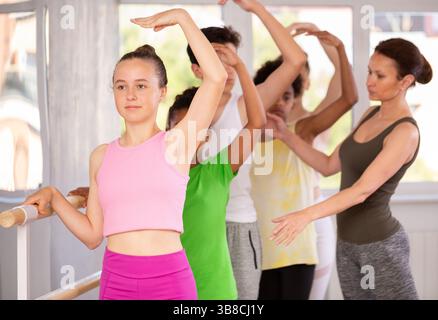 Teen girl mastering third position in amateur ballet class Stock Photo