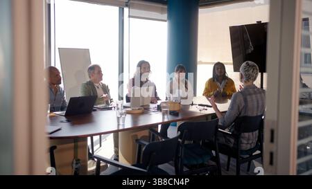 Diverse business team engaging in collaborative discussion in modern office Stock Photo