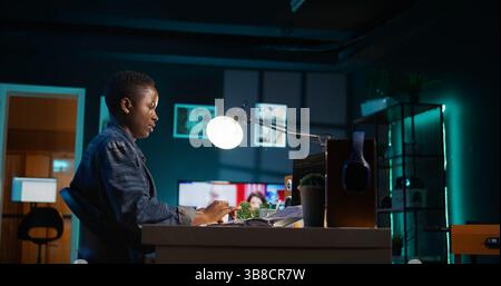 Freelancing admin in home office using laptop to write programming language code. Software technician working from home using notebook device to build application, camera B Stock Photo
