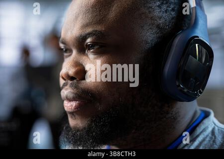 Admin in data center wearing headphones, coordinating deployment of server architecture, improving data processing speed, close up. Server farm expert hearing songs, configuring and testing equipment Stock Photo
