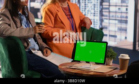 Diverse business experts working with mockup display on tablet, exchanging details in a briefing meeting. CEOs starting a collaboration with leadership skills, fighting for a success story. Camera A. Stock Photo