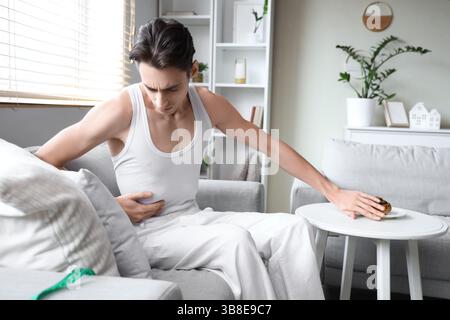 Young man with anorexia refusing from bun at home Stock Photo