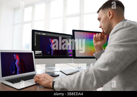 Designer working on different computers at table in office Stock Photo