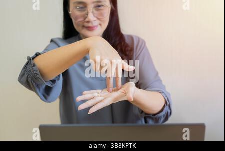 Deaf adult Asian woman talk on video call using sign language with friends. Sign language concept. Selective focus. Stock Photo