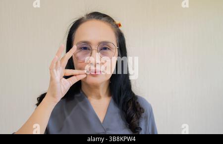 Mature attractive Asian women using sign hand finger language conversation with copy space. Deaf Aid concept. Stock Photo