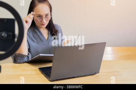 Young adult woman on a video conference call with colleagues working from home. Selective focus. Stock Photo
