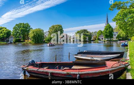 Landscape of Broek in Waterland, picturesque dutch village northeast of Amsterdam, view of pond with boats and church tower on a sunny spring day Stock Photo