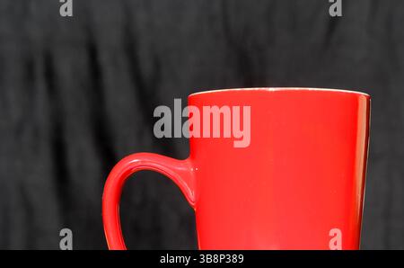 Red mug against a black background Stock Photo