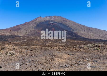 Dramatic View Of Mount Teide Volcano Surrounded By Dark Solidified Lava From Past Eruptions And Rugged Lava Field In Teide National Park Tenerife Spai Stock Photo
