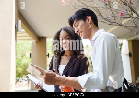 Collaboration and Sustainability. Two professionals discussing eco-friendly initiatives while reviewing documents. Stock Photo