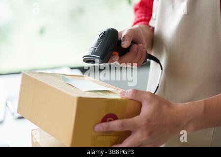 Inventory management with employee scanning packages using barcode scanner Stock Photo