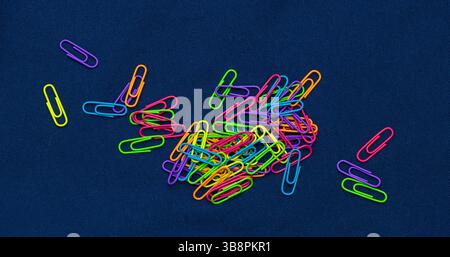Large pile of colorful metal paper clips on dark background Stock Photo