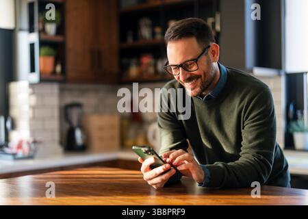 Successful business man professional entrepreneur holding cell phone using smartphone watching video or having mobile chat call. Stock Photo
