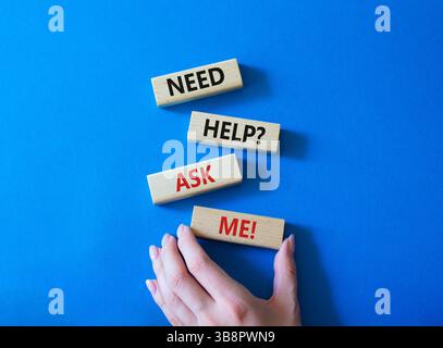 Need help ask me symbol. Concept words Need help ask me on wooden blocks. Beautiful blue background. Businessman hand. Business and Need help ask me c Stock Photo
