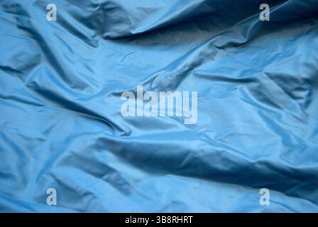 Blue fabric background. Blue creased fabric surface. Stock Photo