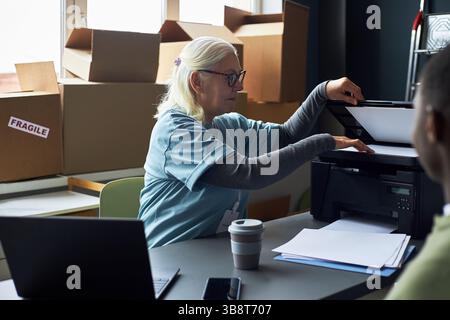 Senior Woman Typing on Computer at Office Desk Stock Photo