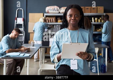 Portrait of African American Woman Holding Clipboards in Work Room Stock Photo