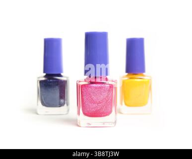 Set of Nail polish with focus on one bottle. Glitter nail polish bottles in a row. Happy colors in pink, yellow and blue. Used to embellish or glam up Stock Photo