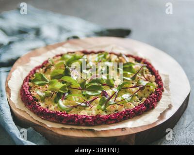 Beetroot pizza crust with fresh swiss chard or mangold, beetroot leaves. Ideas and recipes for vegan snack.Egg-free pizza crust with chia seeds and wh Stock Photo