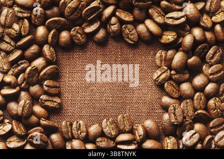Spilled coffee beans frame over linen textile Stock Photo