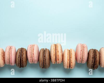 Macarons with copy space. Row of perfect french macarons or macaroons on blue background. Top view or flat lay Stock Photo