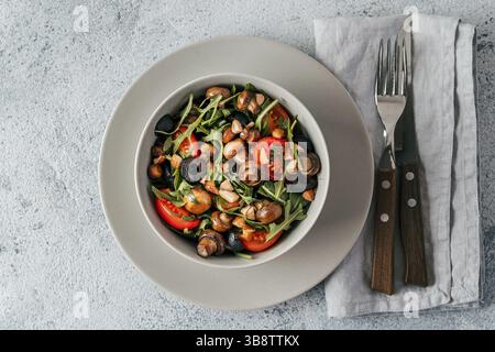 Salad with arugula, mini champignons, cherry tomatoes, black olives, pine nuts. Vegetarian salad top view or flat lay. Copy space. Horizontal banner Stock Photo