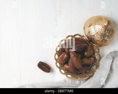 Metal plate of sweet dried dates and linen cloth on gray cement background. Dried dates with copy space. Top view or flat-lay Stock Photo