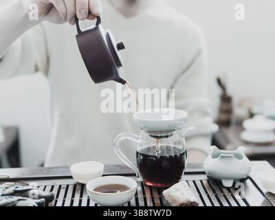Chinese tea ceremony. Master pouring puer tea in glass teapot. Pu erh tea ceremony Stock Photo