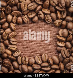 Spilled coffee beans frame over linen textile Stock Photo