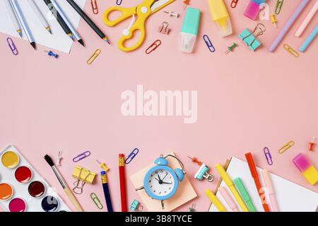 Creative student desk with school supplies and copy space in center. Top view or flat lay. Trendy back to school flat lay on pink background Stock Photo