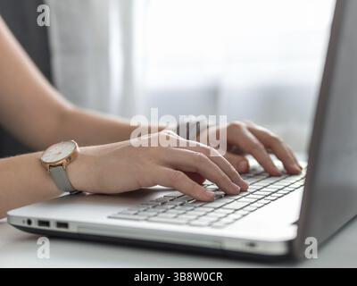 Working from home, contractor, freelance, social media, social marketing concept. Close-up woman's hands typing on laptop keyboard at home. Copy space Stock Photo