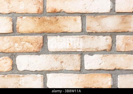 Rustic light brick wall. Textured masonry background. Beige and white tones. Classic construction element. Rough surface for design. Stock Photo