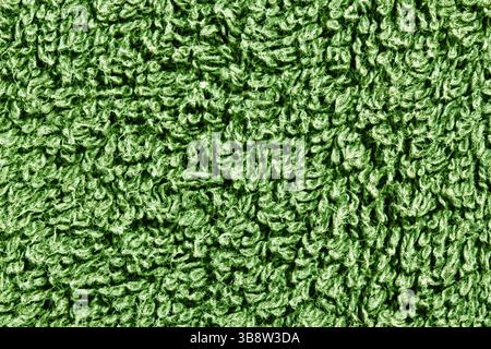 Green towel texture. Closeup of soft terry cloth surface. Fluffy fabric with looped threads. Clean material. Simple textile background for bathroom. Stock Photo