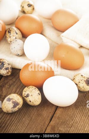 Eggs on textile tablecloth over rustic wooden table Stock Photo