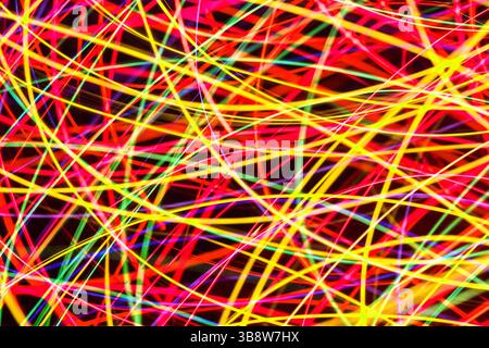 Neon lines pattern on black. Abstract colorful glowing mesh in motion. Bright electric wires concept. Futuristic and dynamic tech background Stock Photo