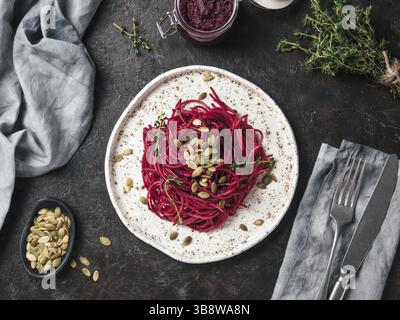 Beetroot pesto or hummus. Homemade beet pesto sauce in glass jar and fresh thyme on dark black background. Copy space for text. Ideas and recipes for Stock Photo