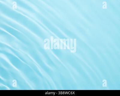 Ripple water texture on blue pool background. Shadow of water on sunlight. Mockup for product, spa or travel background. Marble blue water surface as Stock Photo